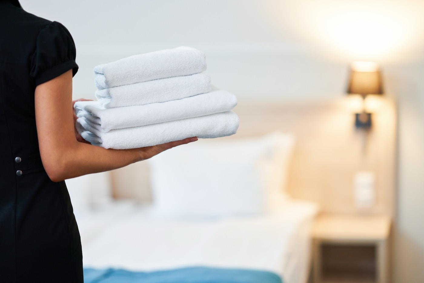 hotel housekeeper replacing towels